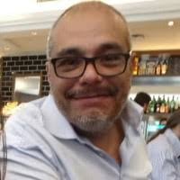 Jorge Ullúa - Fundador del Colegio Árbol del Norte, hombre con barba y gafas, camisa a rayas